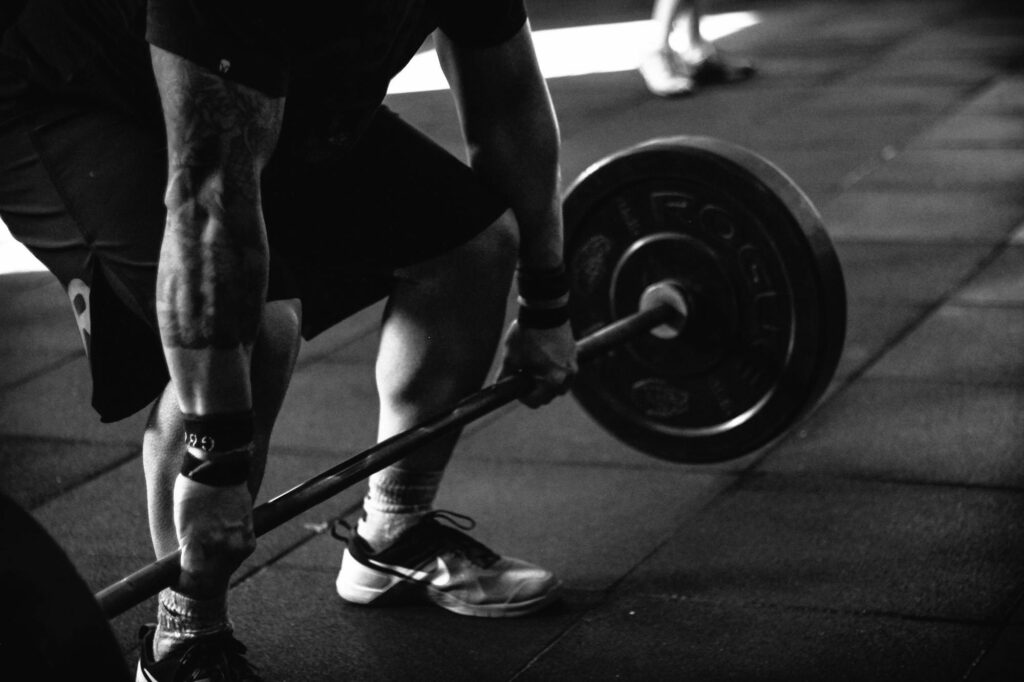 Home A powerful black and white image of a man deadlifting in a gym, showcasing strength and fitness.